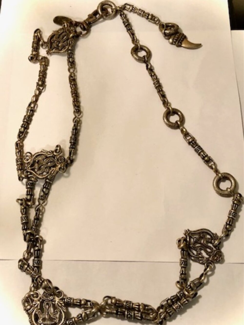 An ornate metal belt with unusual designs silver toned from the Limited